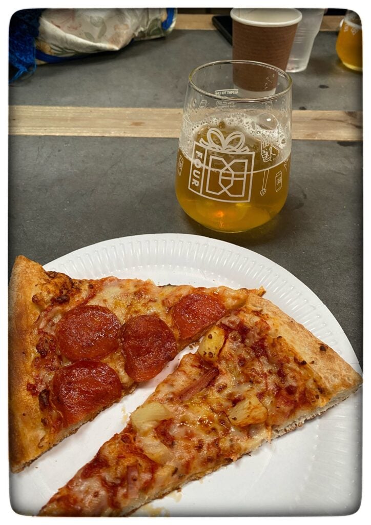 Image of two slices of pizza and a glass of craft beer