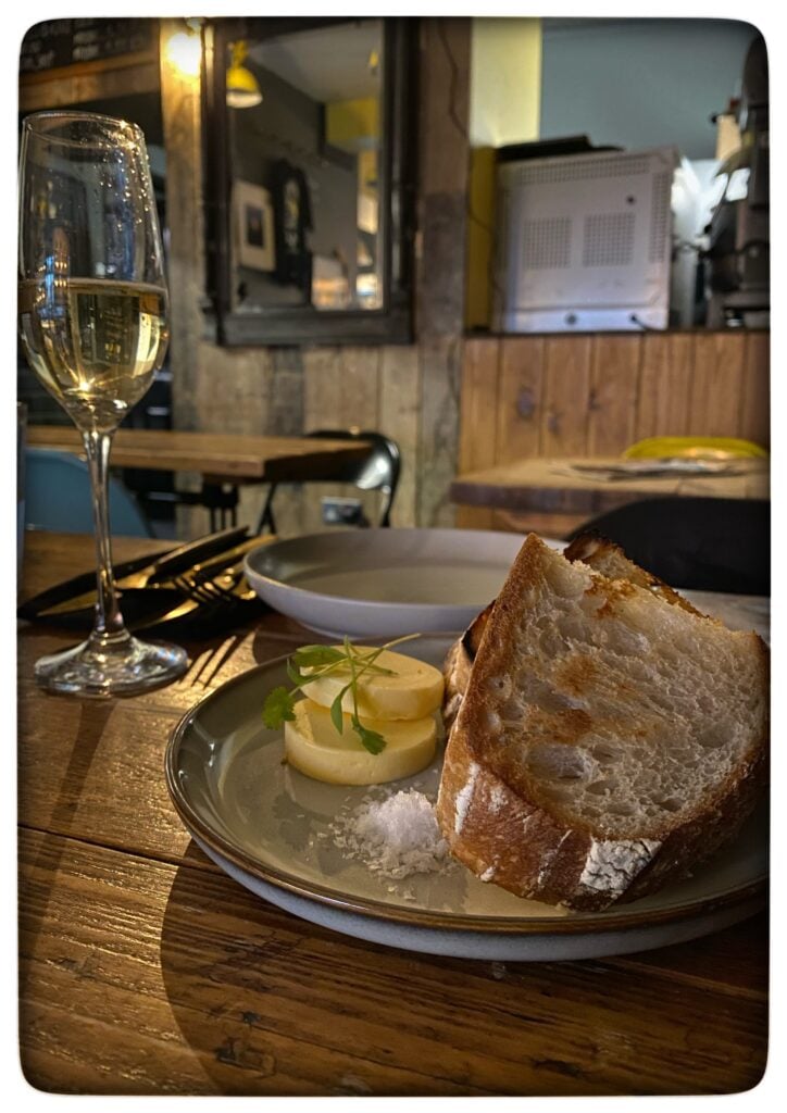 Image of a glass of sparkling wine and a plaet of bread and butter