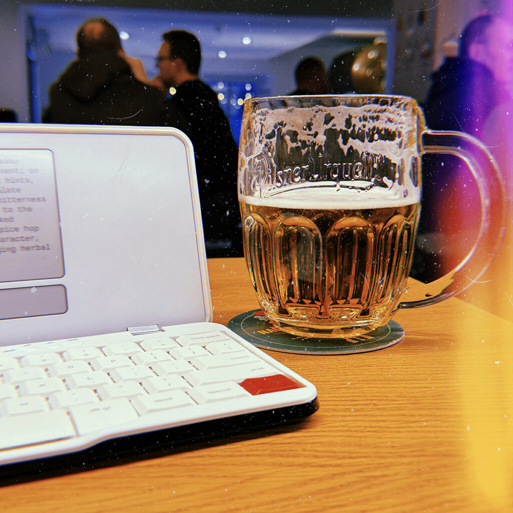 Image of an electronic typewriter and a glass of beer