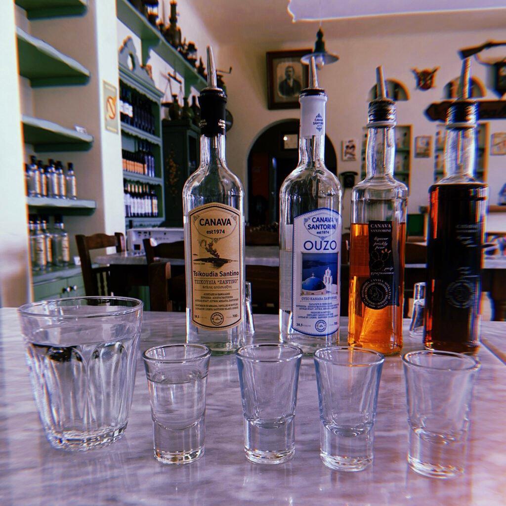 Image of four shot glasses, a water glasss and four bottles of spirits