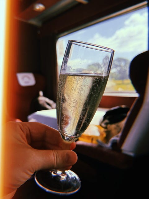 Image of a glasss of Prosecco on a train